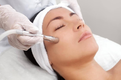 Woman receiving a microdermabrasion treatment at a spa.