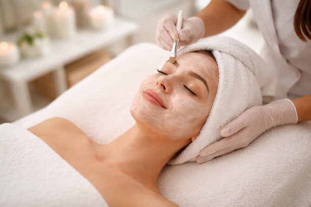 Client relaxing during facials at a clean and calming spa setting.