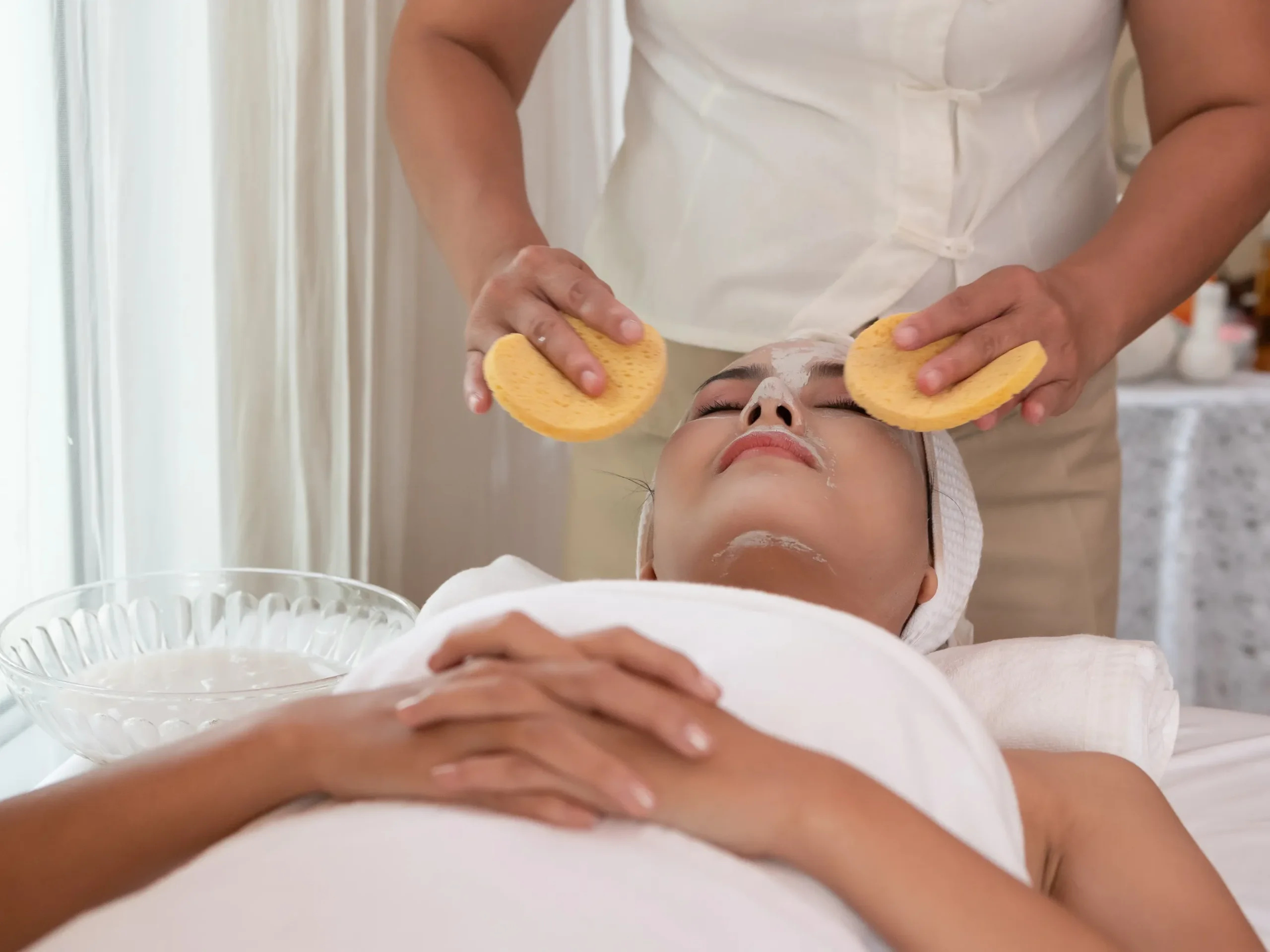 Esthetician performing deep cleansing as part of professional facials.