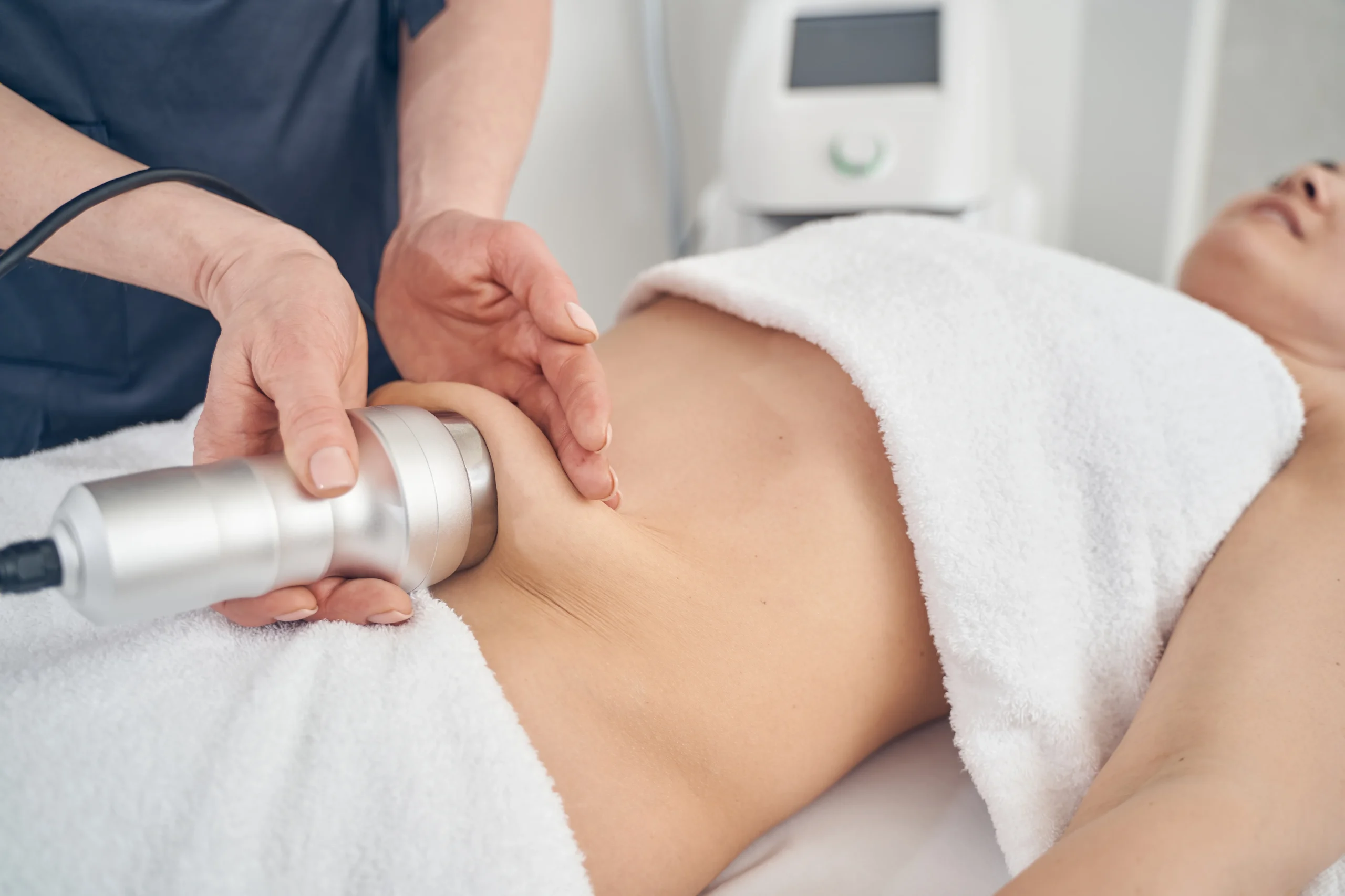 Client receiving ultrasonic cavitation treatment in a professional body contouring clinic.